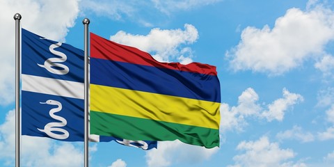 Martinique and Mauritius flag waving in the wind against white cloudy blue sky together. Diplomacy...