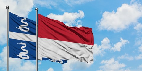 Martinique and Monaco flag waving in the wind against white cloudy blue sky together. Diplomacy concept, international relations.