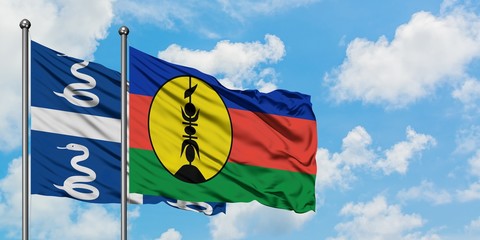 Martinique and New Caledonia flag waving in the wind against white cloudy blue sky together. Diplomacy concept, international relations.