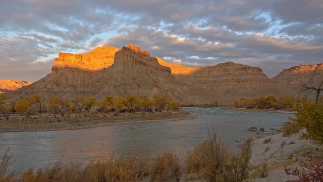 Cliff tops lighting up as sunlight reflects off the sandstone next to the Green River in Utah.