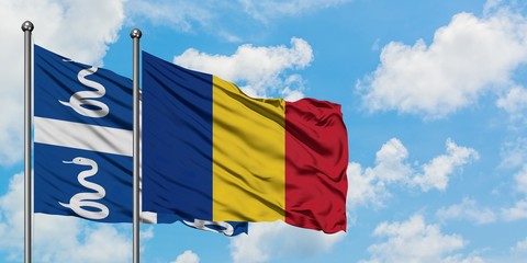 Martinique and Romania flag waving in the wind against white cloudy blue sky together. Diplomacy concept, international relations.