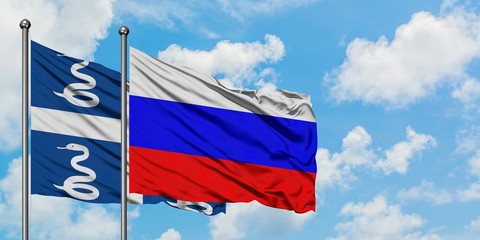 Martinique and Russia flag waving in the wind against white cloudy blue sky together. Diplomacy...