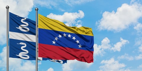 Martinique and Venezuela flag waving in the wind against white cloudy blue sky together. Diplomacy concept, international relations.