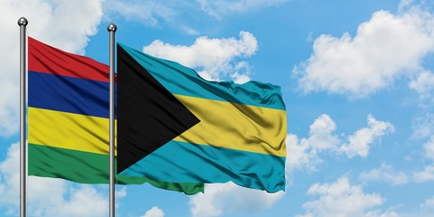 Mauritius and Bahamas flag waving in the wind against white cloudy blue sky together. Diplomacy concept, international relations.