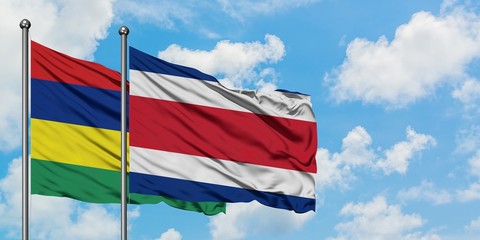 Mauritius and Costa Rica flag waving in the wind against white cloudy blue sky together. Diplomacy concept, international relations.