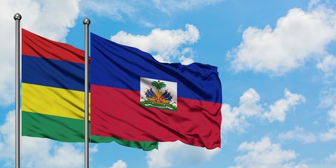 Mauritius and Haiti flag waving in the wind against white cloudy blue sky together. Diplomacy concept, international relations.