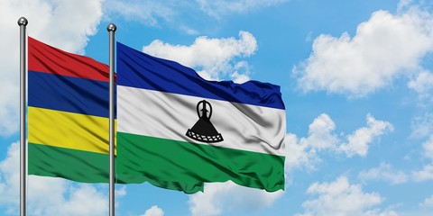 Mauritius and Lesotho flag waving in the wind against white cloudy blue sky together. Diplomacy concept, international relations.