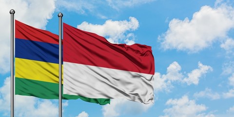Mauritius and Monaco flag waving in the wind against white cloudy blue sky together. Diplomacy concept, international relations.