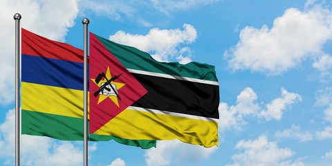 Mauritius and Mozambique flag waving in the wind against white cloudy blue sky together. Diplomacy concept, international relations.