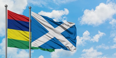 Mauritius and Scotland flag waving in the wind against white cloudy blue sky together. Diplomacy concept, international relations.