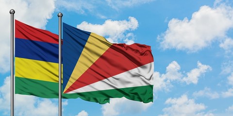 Mauritius and Seychelles flag waving in the wind against white cloudy blue sky together. Diplomacy concept, international relations.