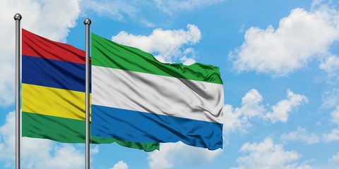 Mauritius and Sierra Leone flag waving in the wind against white cloudy blue sky together. Diplomacy concept, international relations.