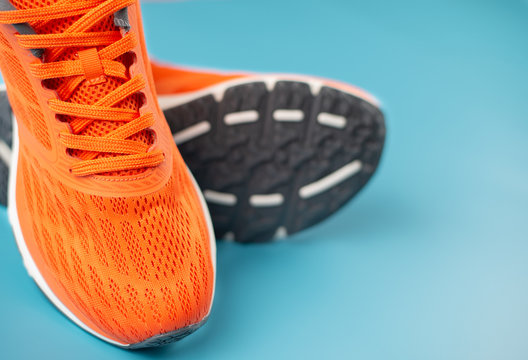 Orange sport shoes on a blue background. Concept for good health.