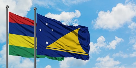 Mauritius and Tokelau flag waving in the wind against white cloudy blue sky together. Diplomacy concept, international relations.