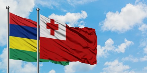 Mauritius and Tonga flag waving in the wind against white cloudy blue sky together. Diplomacy concept, international relations.