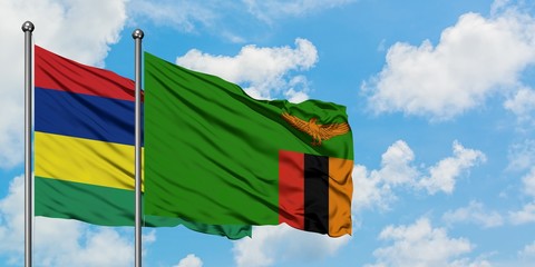 Mauritius and Zambia flag waving in the wind against white cloudy blue sky together. Diplomacy concept, international relations.