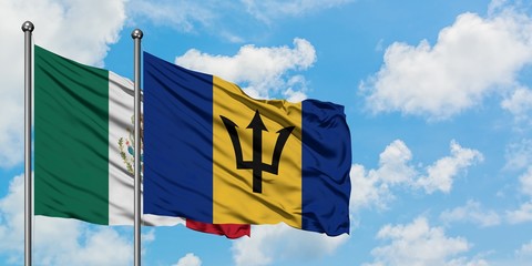 Mexico and Barbados flag waving in the wind against white cloudy blue sky together. Diplomacy concept, international relations.