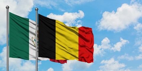 Mexico and Belgium flag waving in the wind against white cloudy blue sky together. Diplomacy concept, international relations.