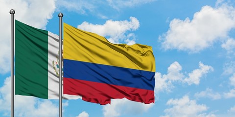 Mexico and Colombia flag waving in the wind against white cloudy blue sky together. Diplomacy concept, international relations.