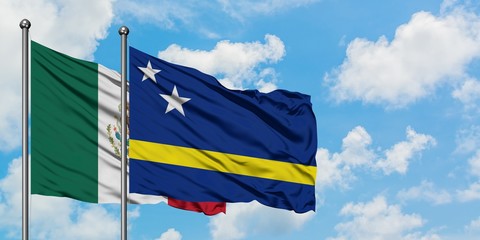 Mexico and Curacao flag waving in the wind against white cloudy blue sky together. Diplomacy concept, international relations.