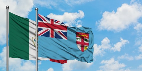 Mexico and Fiji flag waving in the wind against white cloudy blue sky together. Diplomacy concept, international relations.