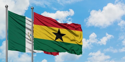 Mexico and Ghana flag waving in the wind against white cloudy blue sky together. Diplomacy concept, international relations.