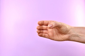 The hand is empty, something wrapped in a brush. On a purple background.