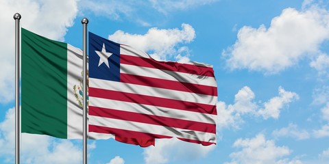 Mexico and Liberia flag waving in the wind against white cloudy blue sky together. Diplomacy concept, international relations.