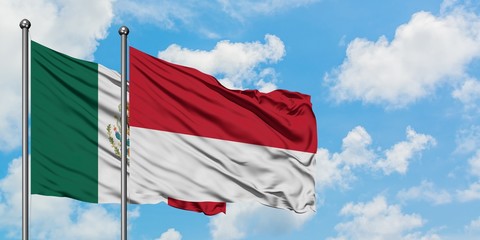 Mexico and Monaco flag waving in the wind against white cloudy blue sky together. Diplomacy concept, international relations.