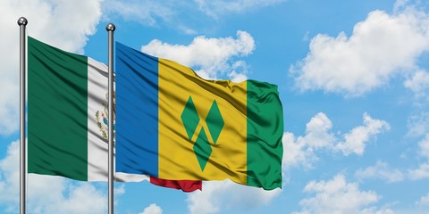 Mexico and Saint Vincent And The Grenadines flag waving in the wind against white cloudy blue sky...