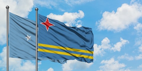 Micronesia and Aruba flag waving in the wind against white cloudy blue sky together. Diplomacy concept, international relations.
