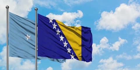 Micronesia and Bosnia Herzegovina flag waving in the wind against white cloudy blue sky together. Diplomacy concept, international relations.