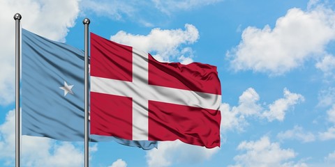 Micronesia and Denmark flag waving in the wind against white cloudy blue sky together. Diplomacy concept, international relations.
