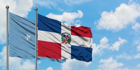 Micronesia and Dominican Republic flag waving in the wind against white cloudy blue sky together. Diplomacy concept, international relations.