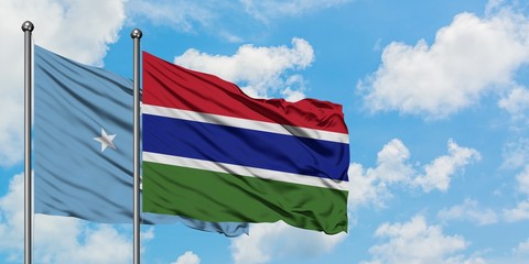 Micronesia and Gambia flag waving in the wind against white cloudy blue sky together. Diplomacy concept, international relations.