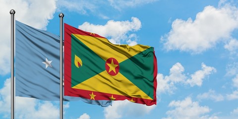 Micronesia and Grenada flag waving in the wind against white cloudy blue sky together. Diplomacy concept, international relations.