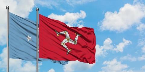 Micronesia and Isle Of Man flag waving in the wind against white cloudy blue sky together....