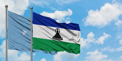 Micronesia and Lesotho flag waving in the wind against white cloudy blue sky together. Diplomacy...