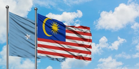 Micronesia and Malaysia flag waving in the wind against white cloudy blue sky together. Diplomacy concept, international relations.