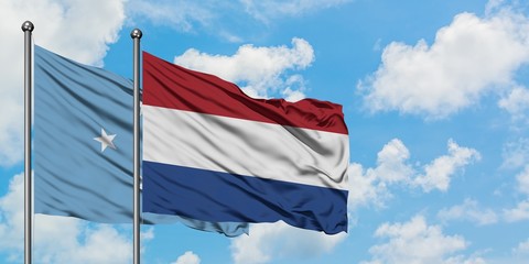 Micronesia and Netherlands flag waving in the wind against white cloudy blue sky together. Diplomacy concept, international relations.
