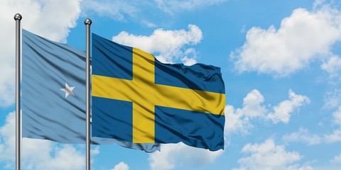 Micronesia and Sweden flag waving in the wind against white cloudy blue sky together. Diplomacy concept, international relations.