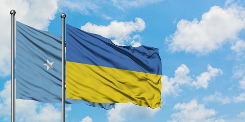 Micronesia and Ukraine flag waving in the wind against white cloudy blue sky together. Diplomacy concept, international relations.