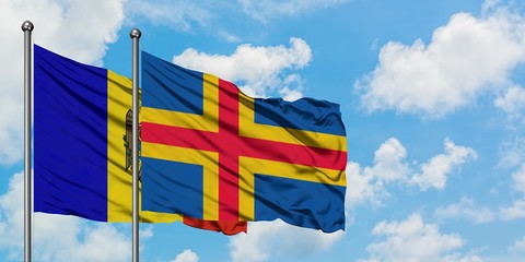 Moldova and Aland Islands flag waving in the wind against white cloudy blue sky together. Diplomacy...