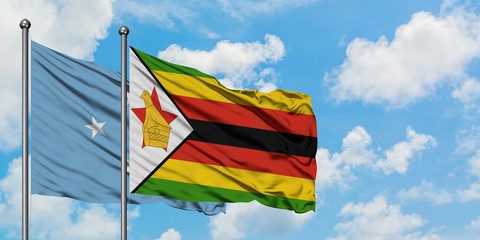Micronesia and Zimbabwe flag waving in the wind against white cloudy blue sky together. Diplomacy concept, international relations.