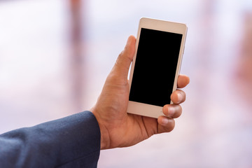 White smartphone with black blank in Hand businessman. business communication concept.