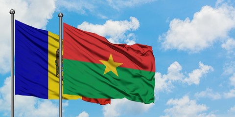Moldova and Burkina Faso flag waving in the wind against white cloudy blue sky together. Diplomacy concept, international relations.