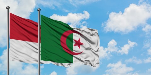 Monaco and Algeria flag waving in the wind against white cloudy blue sky together. Diplomacy concept, international relations.