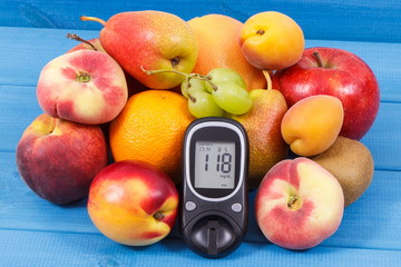 Glucometer and fresh natural fruits containing vitamins for healthy lifestyles of diabetics