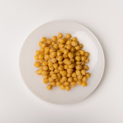 Cooked chickpeas on a white plate 