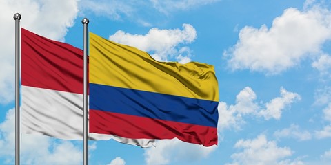 Monaco and Colombia flag waving in the wind against white cloudy blue sky together. Diplomacy concept, international relations.